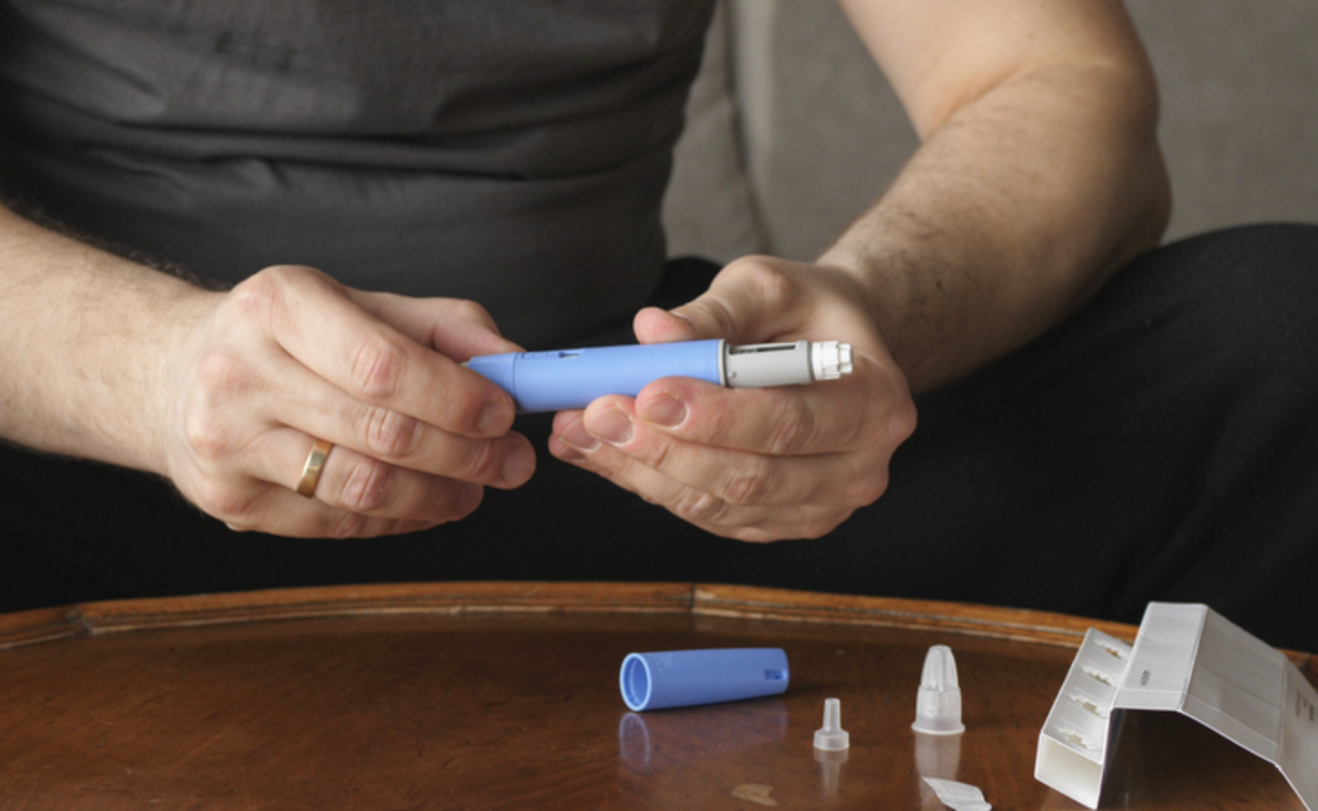 hands and arms of white male preparing a self-injection